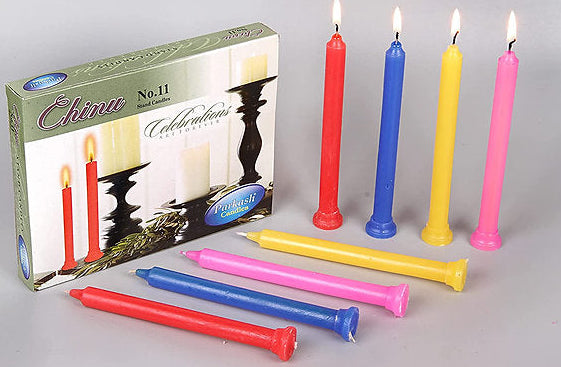 Colorful candles in front of their packaging box on a gray background